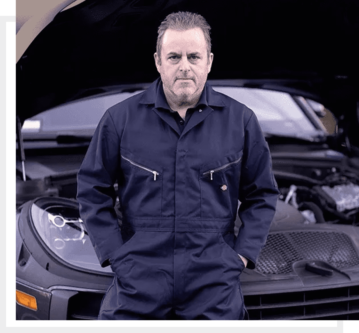 Auto technician standing by open hood